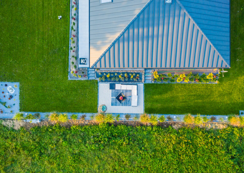 widok z drona na dach domu modułowegom wokół którego rośnie zielona trawa