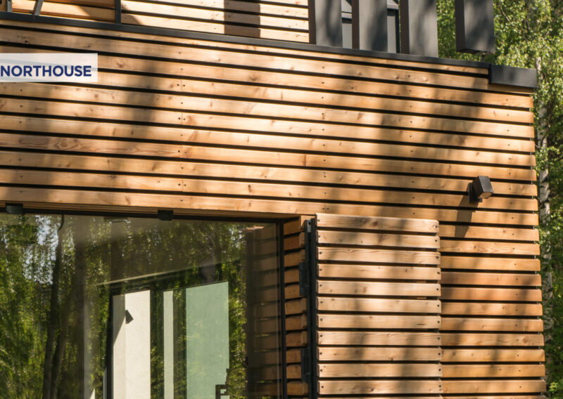 drewniana elewacja domu prefabrykowanego z dużym oknem i okiennicami